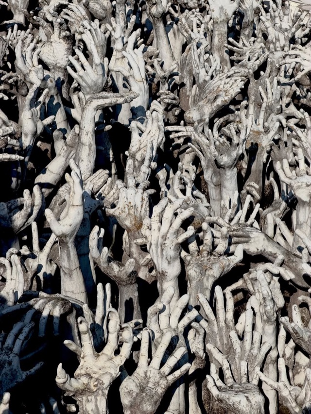A sea of sculpted white hands reaching upward